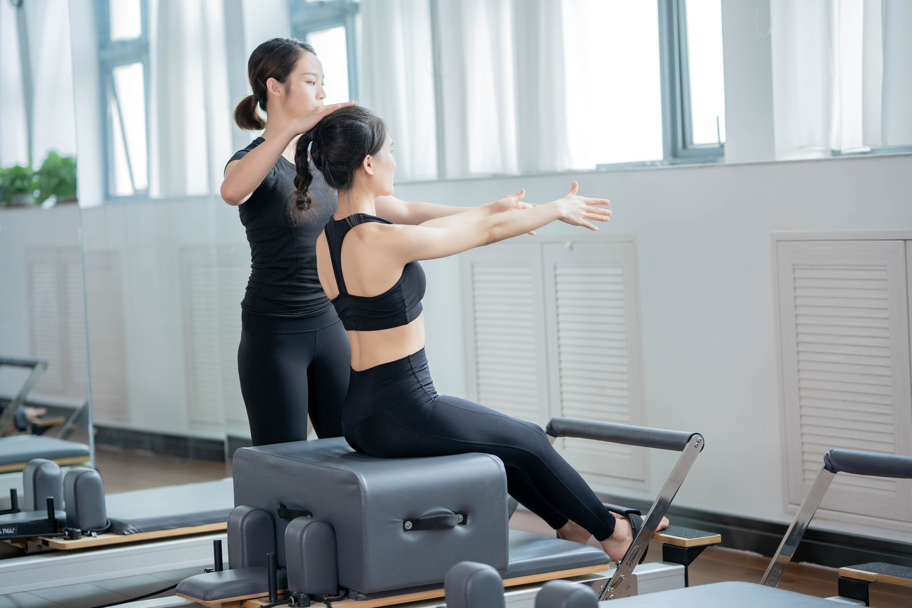 Gym Instructor assisting a Woman 